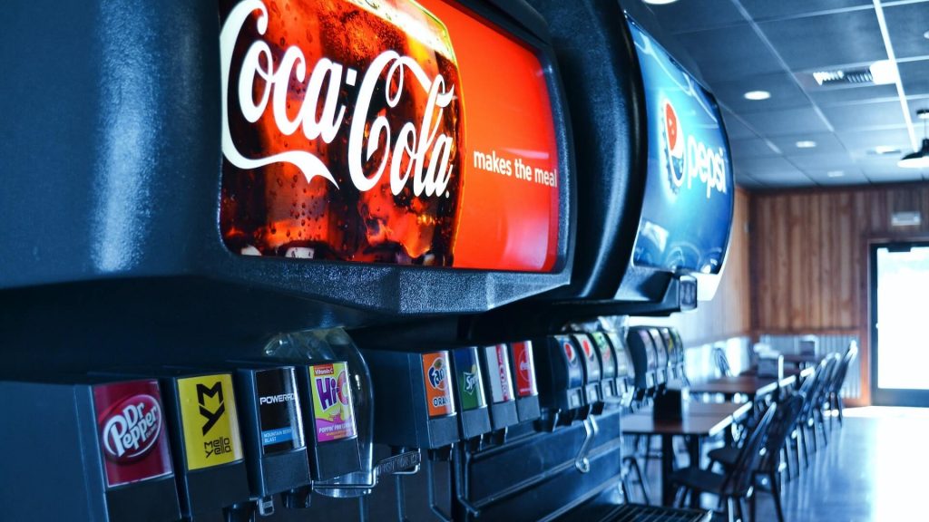 Dos máquinas: Una representando a Coca-Cola y la otra a Pepsi