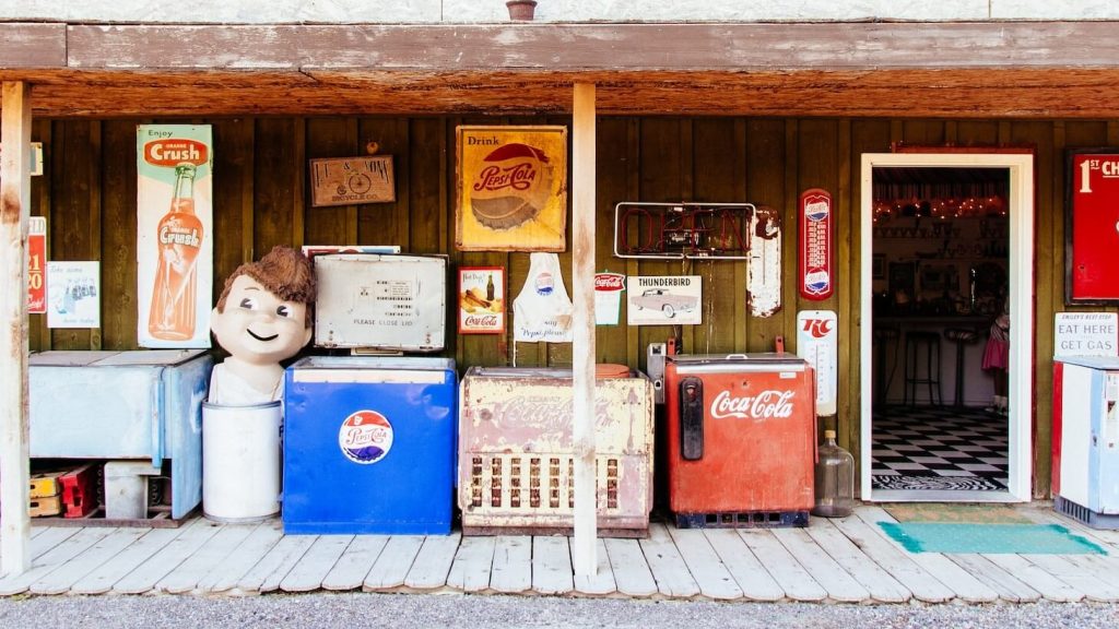 Una vieja tienda con dos congeladores: Uno con productos de Coca-Cola y el otro con productos de Pepsi